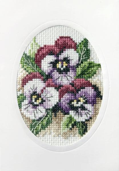 Complete cross stitch kit featuring pansies design, includes fabric, threads, card, envelope, and needle.