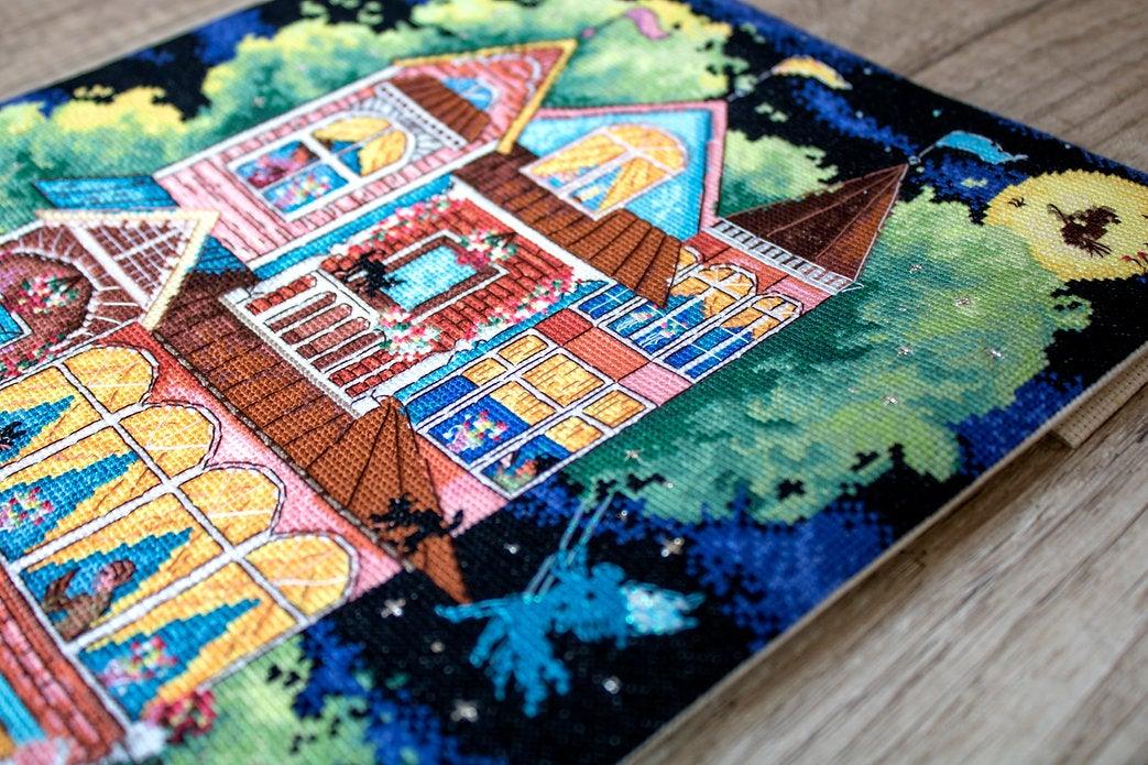 Counted cross stitch kit featuring a fairy tale house design with colorful threads and Aida canvas.