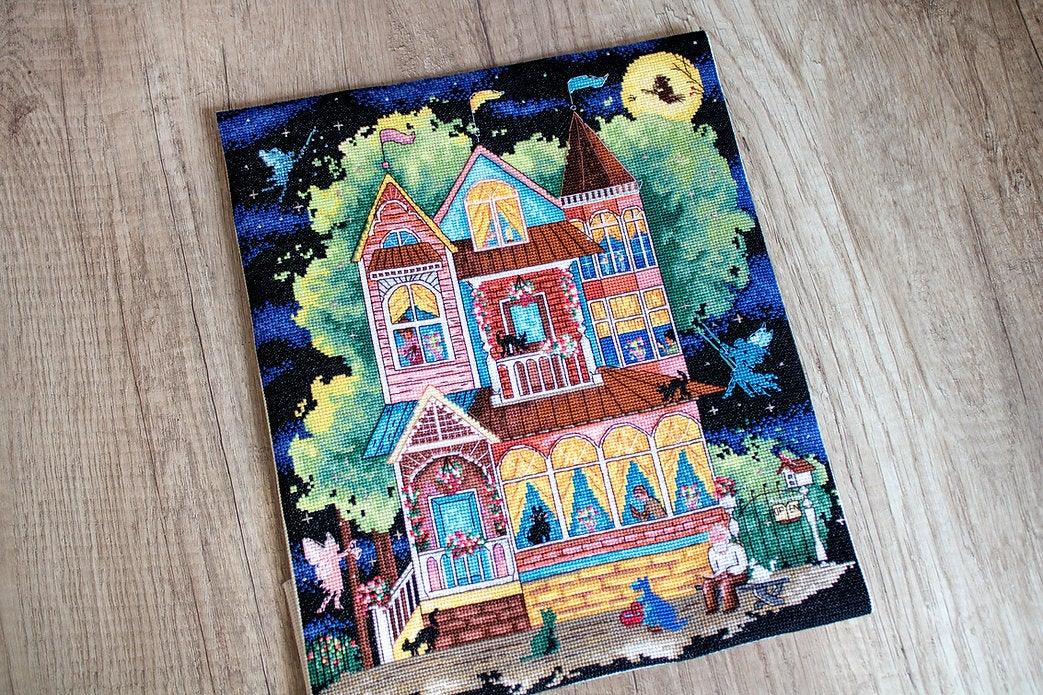 Counted cross stitch kit featuring a fairy tale house design with colorful threads and Aida canvas.