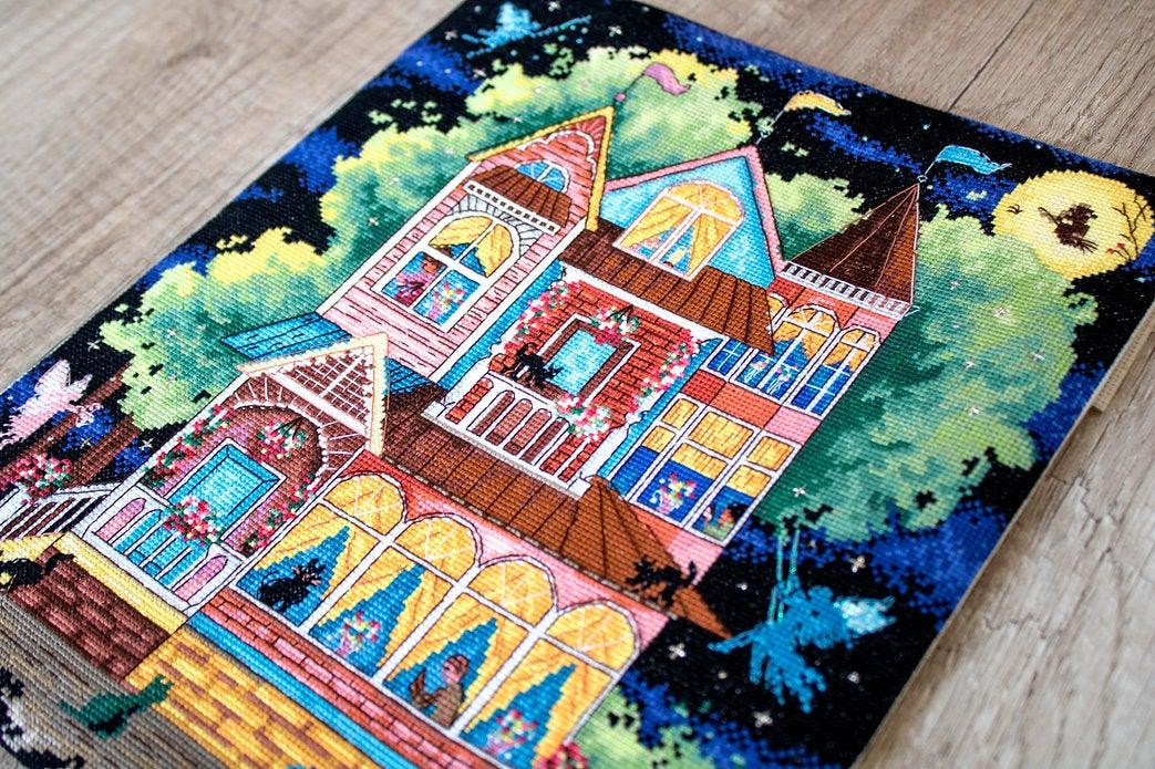 Counted cross stitch kit featuring a fairy tale house design with colorful threads and Aida canvas.