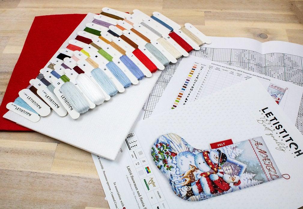 Counted Cross Stitch Kit featuring a Snowman and Santa design, includes colorful threads and canvas.