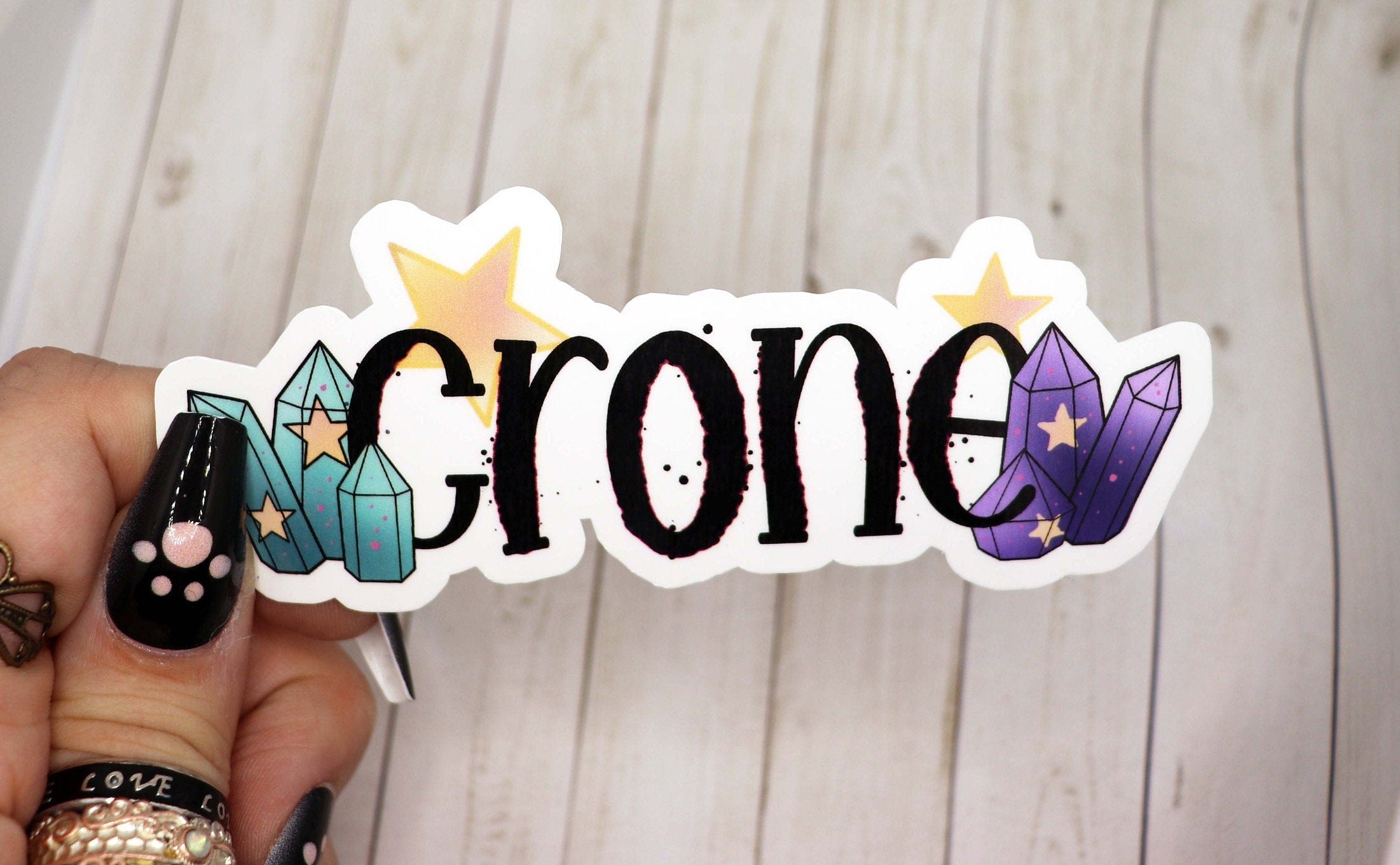 A 3-inch Crone vinyl sticker featuring a unique design, perfect for personalizing various items like water bottles and laptops.