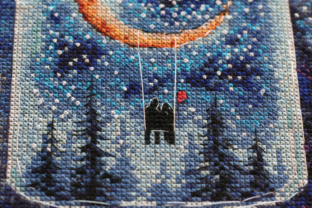 Cross-stitch kit A month for lovers AH-095 featuring dark blue canvas, colorful floss, and stitching supplies.