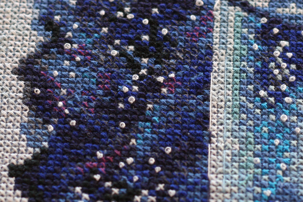 Cross-stitch kit A month for lovers AH-095 featuring dark blue canvas, colorful floss, and stitching supplies.