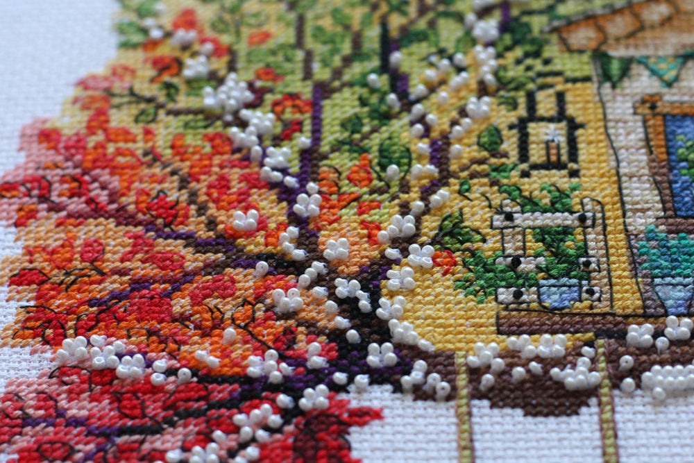 Cross-stitch kit featuring a cat house design with colorful threads and beads, perfect for crafting enthusiasts.