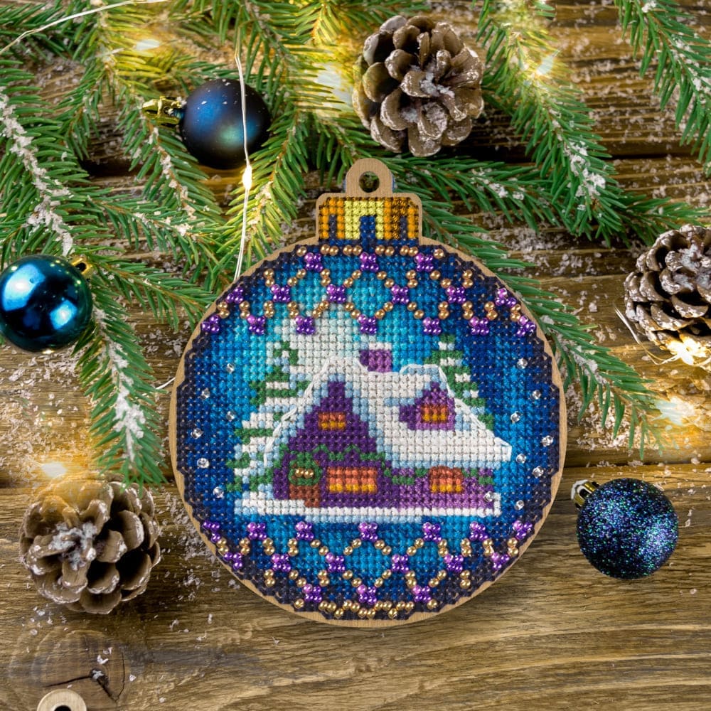 Cross-stitch kit on wood FLW-019 featuring a plywood blank, colorful threads, beads, and embroidery tools for creating Christmas tree decorations.