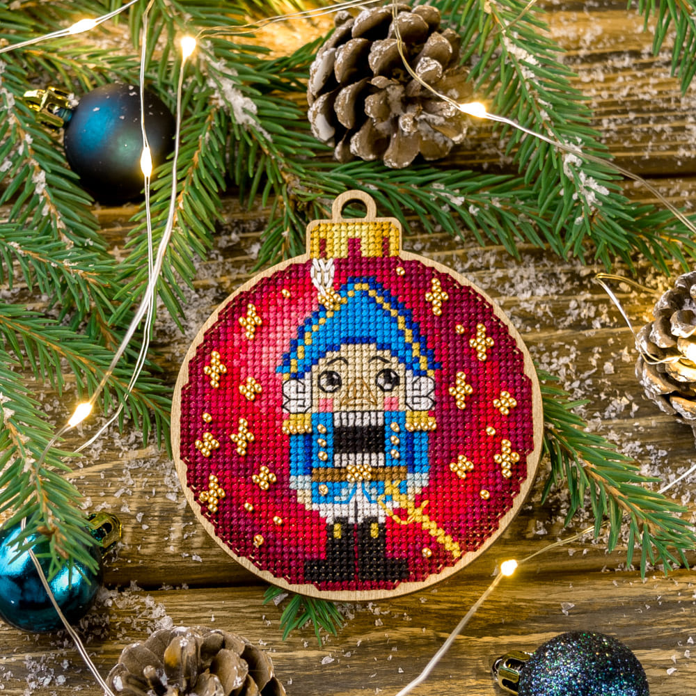 Cross-stitch kit on wood FLW-004 featuring colorful threads, beads, and a plywood blank for creating Christmas tree decorations.