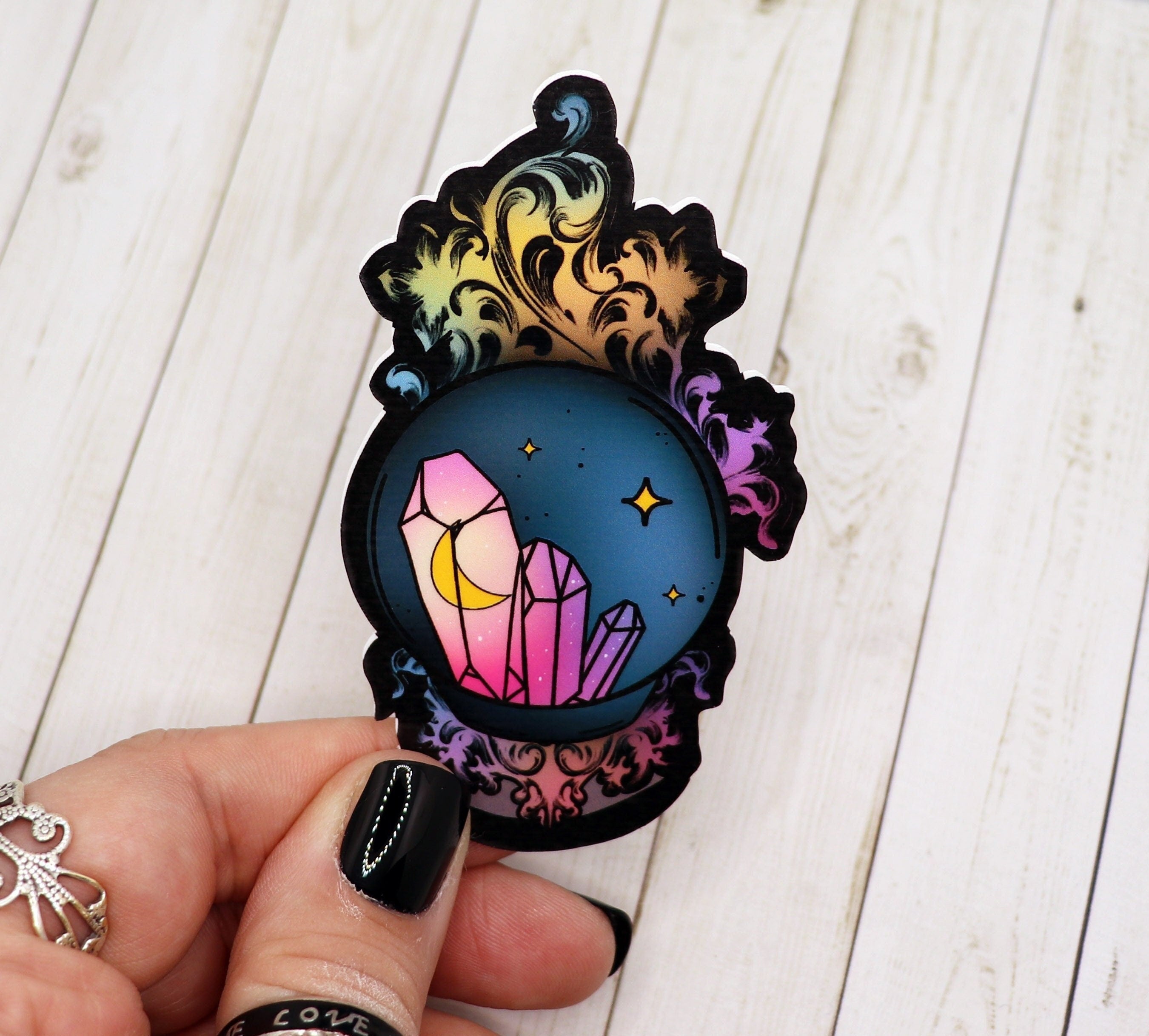 A vibrant 3-inch crystal ball vinyl sticker on a matte surface, showcasing intricate designs and colors.