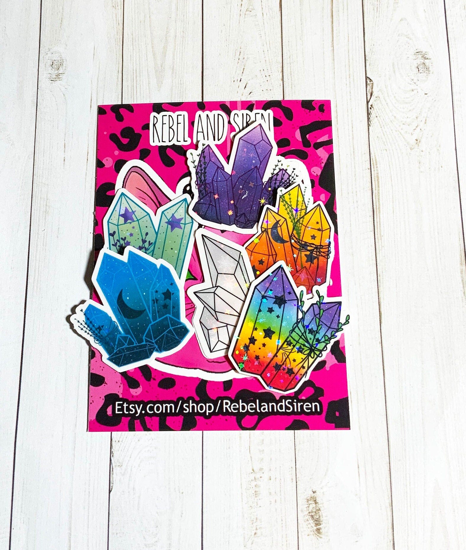 A vibrant Crystal Sticker Pack featuring 6 holographic stickers on a matte vinyl background, showcasing their unique designs.