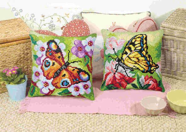 Cushion cross stitch kit featuring a butterfly design, including printed canvas, colorful yarn, needle, and instructions.