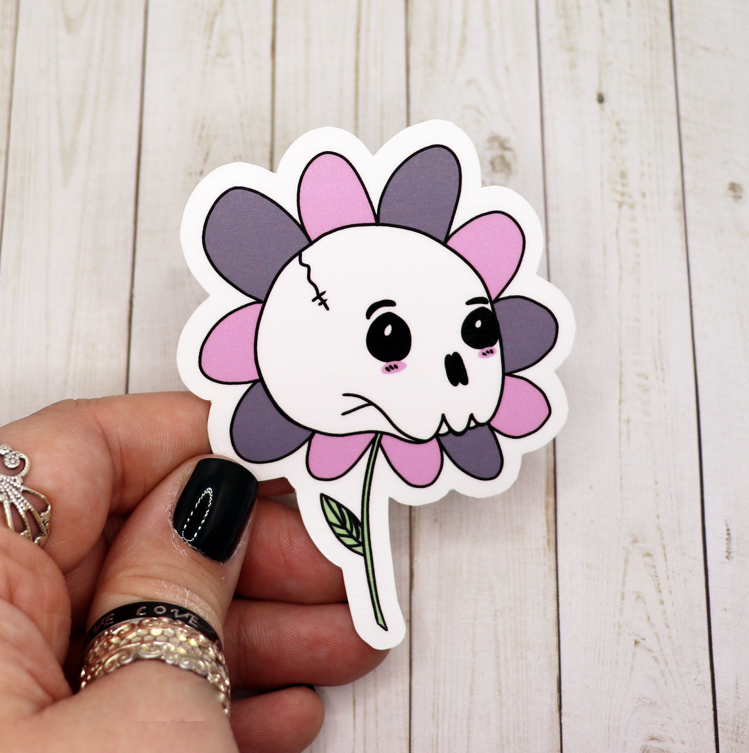 A cute skull flower sticker featuring a whimsical skull surrounded by colorful flowers, perfect for personalizing various items.