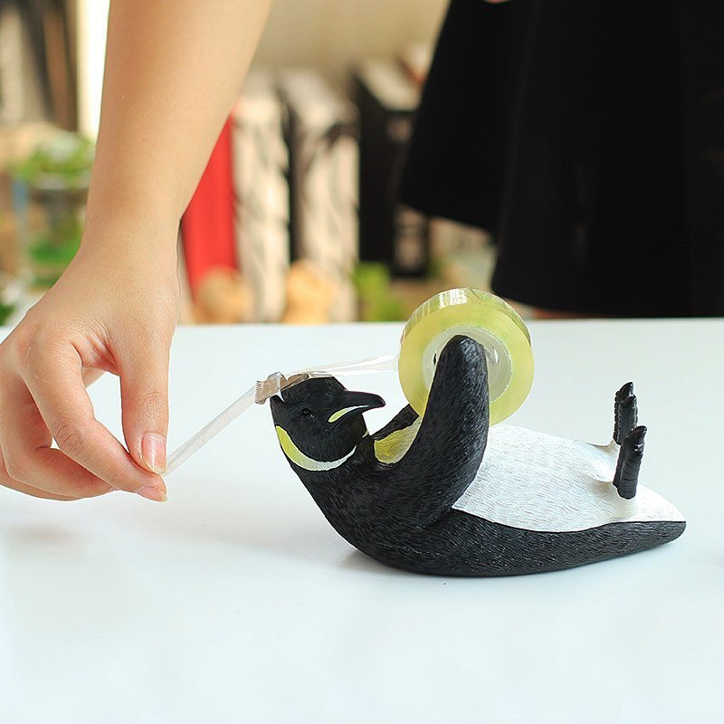 Penguin-shaped tape dispenser in use.