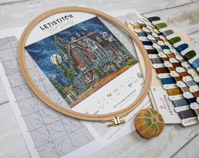 Decorating the Haunted House L8045 Counted Cross Stitch Kit featuring Aida canvas, colorful threads, and detailed instruction chart.