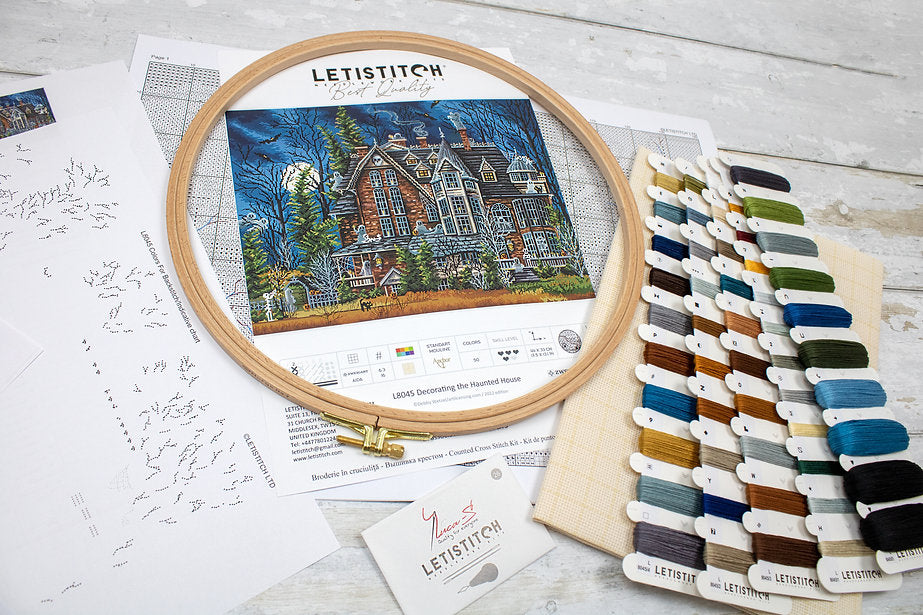 Decorating the Haunted House L8045 Counted Cross Stitch Kit featuring Aida canvas, colorful threads, and detailed instruction chart.