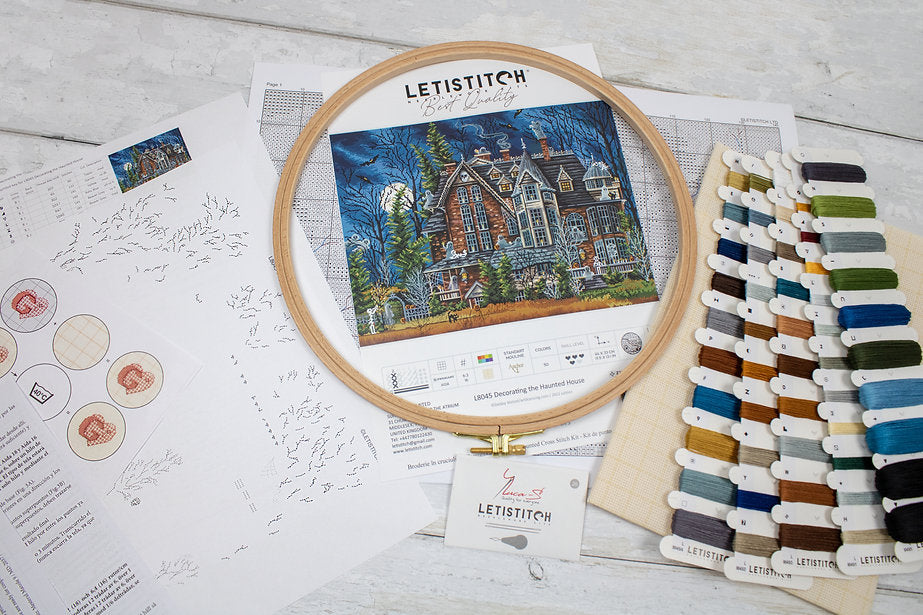 Decorating the Haunted House L8045 Counted Cross Stitch Kit featuring Aida canvas, colorful threads, and detailed instruction chart.