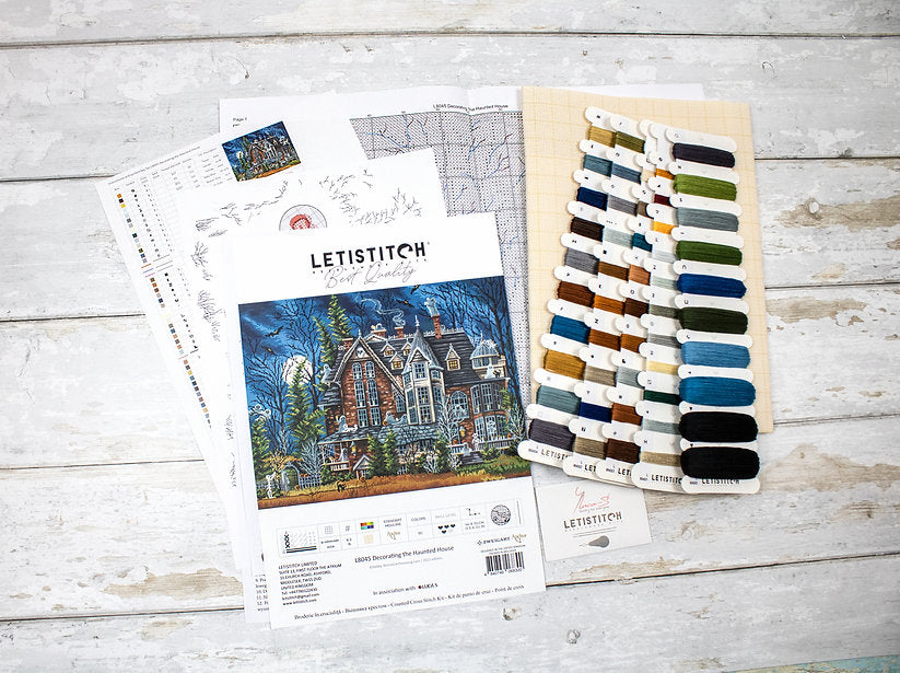 Decorating the Haunted House L8045 Counted Cross Stitch Kit featuring Aida canvas, colorful threads, and detailed instruction chart.