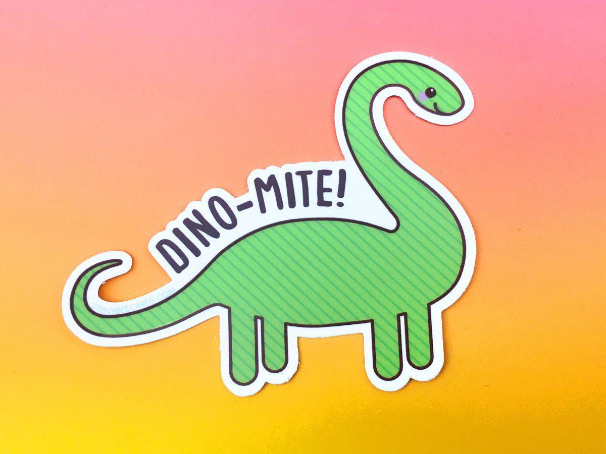 A colorful vinyl sticker featuring a happy dinosaur with the pun 'Dino-mite!' perfect for personalizing items.