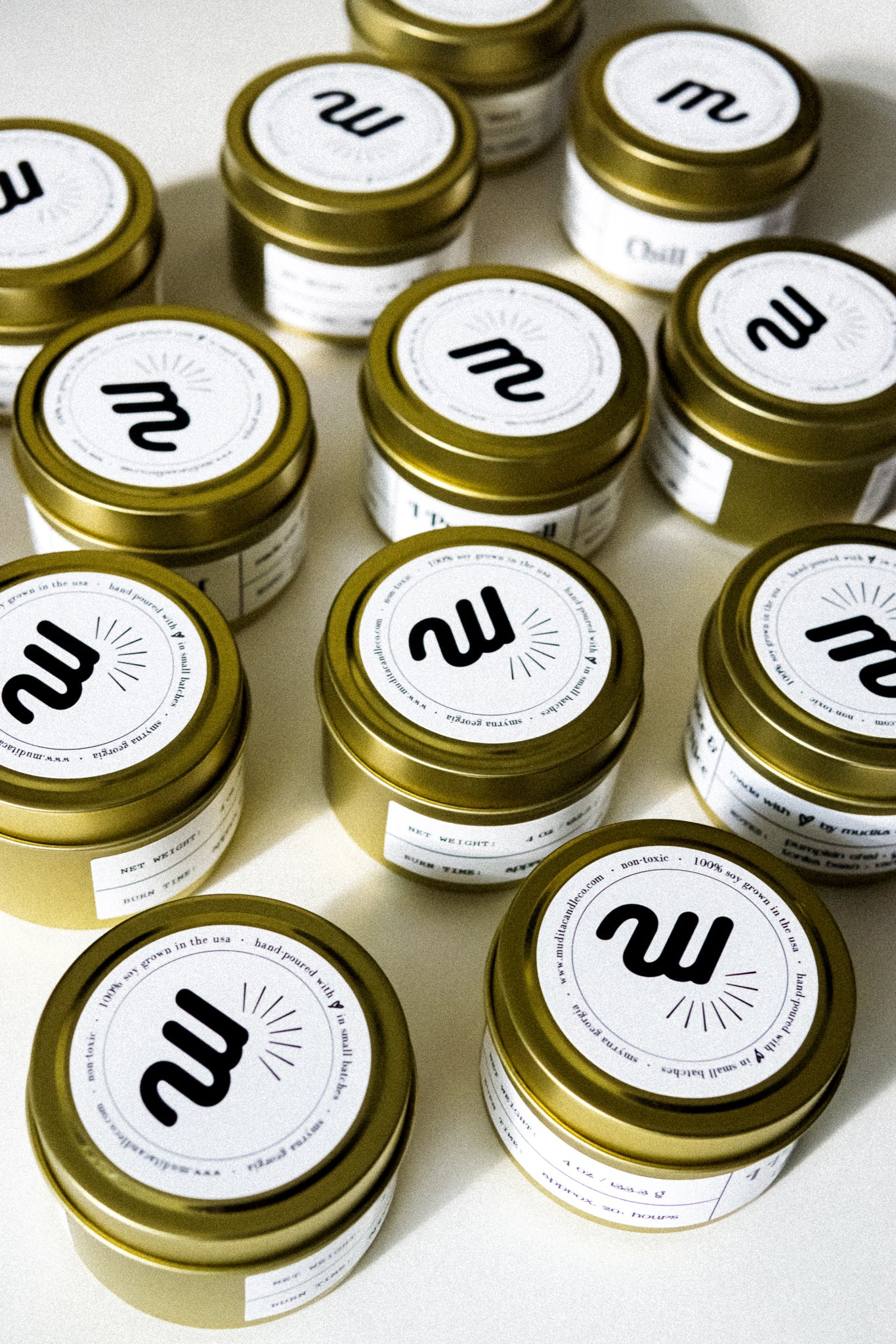 A gold tin jar containing the Eat, Drink, & Be Rosemary Gold Travel Candle, showcasing its elegant design and natural ingredients.