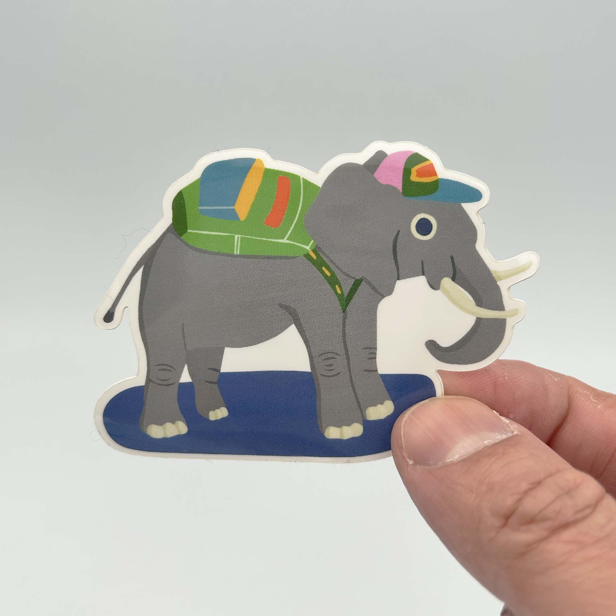 A colorful vinyl sticker featuring an elephant wearing a backpack and a hat, perfect for personalizing items.