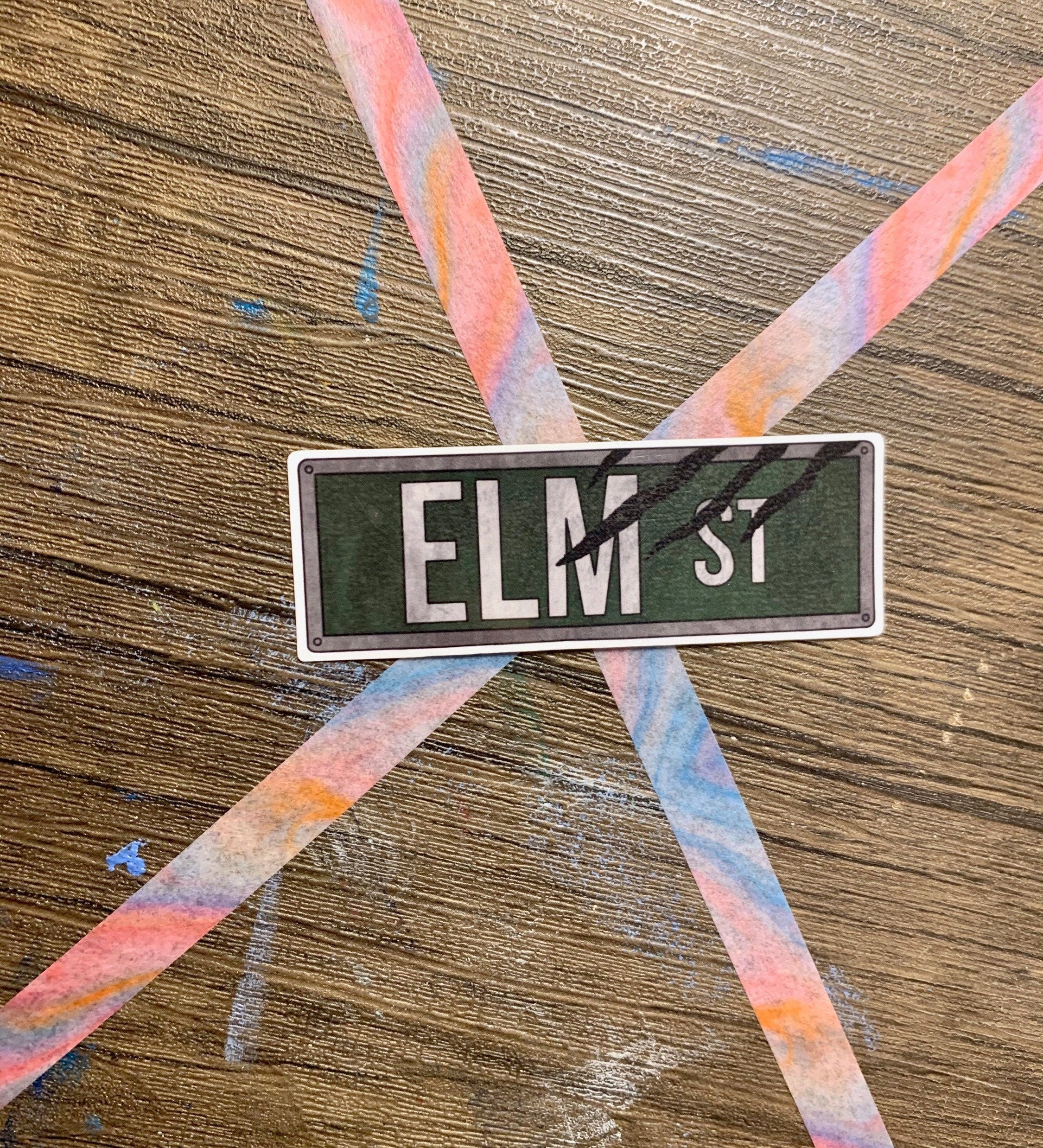 Elm Street Street Sign Sticker featuring iconic design from Nightmare on Elm Street, perfect for personalizing items.