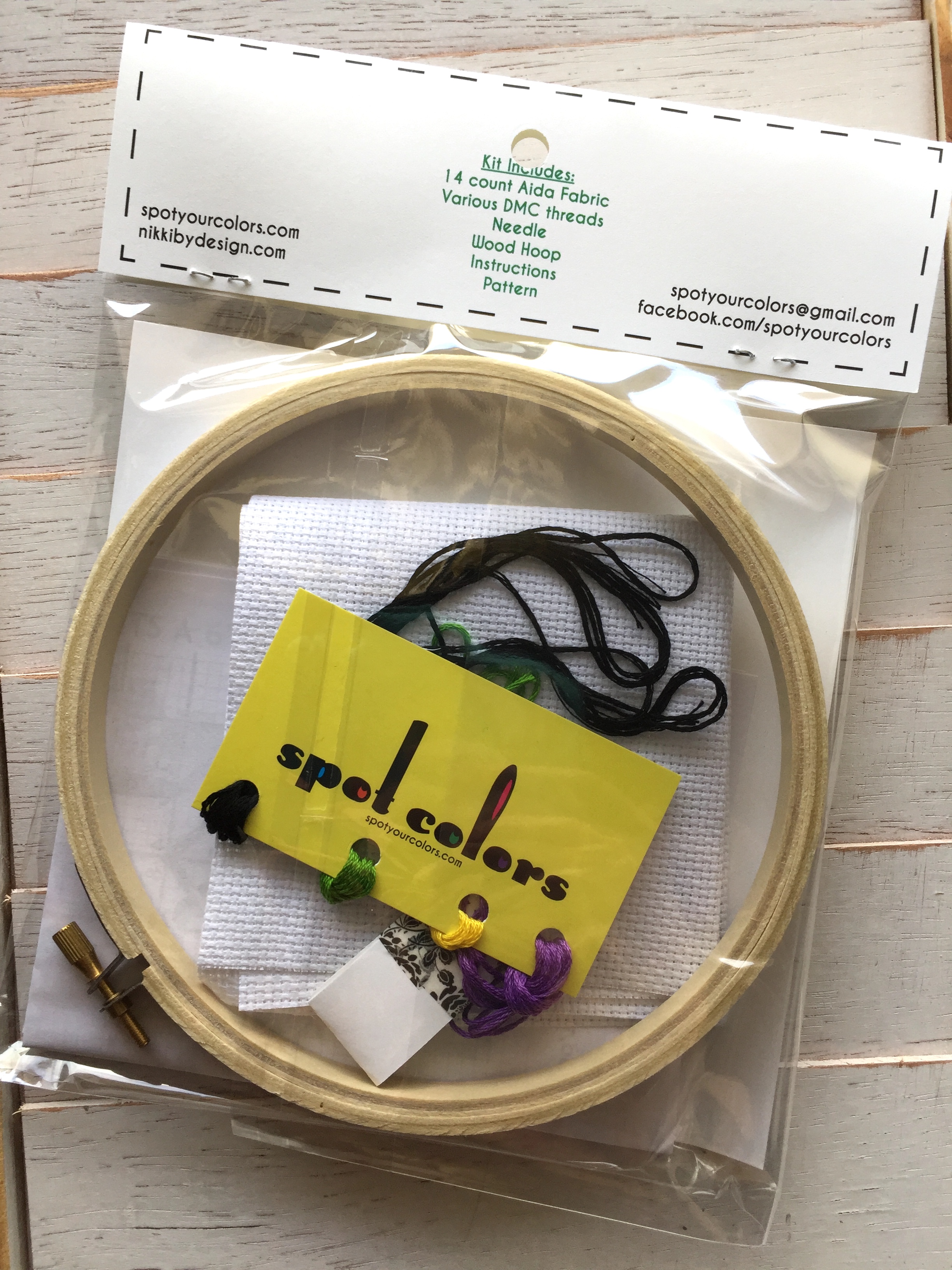 A colorful counted cross stitch kit featuring the phrase 'Ew, People' in cursive surrounded by floral designs, complete with all necessary supplies.