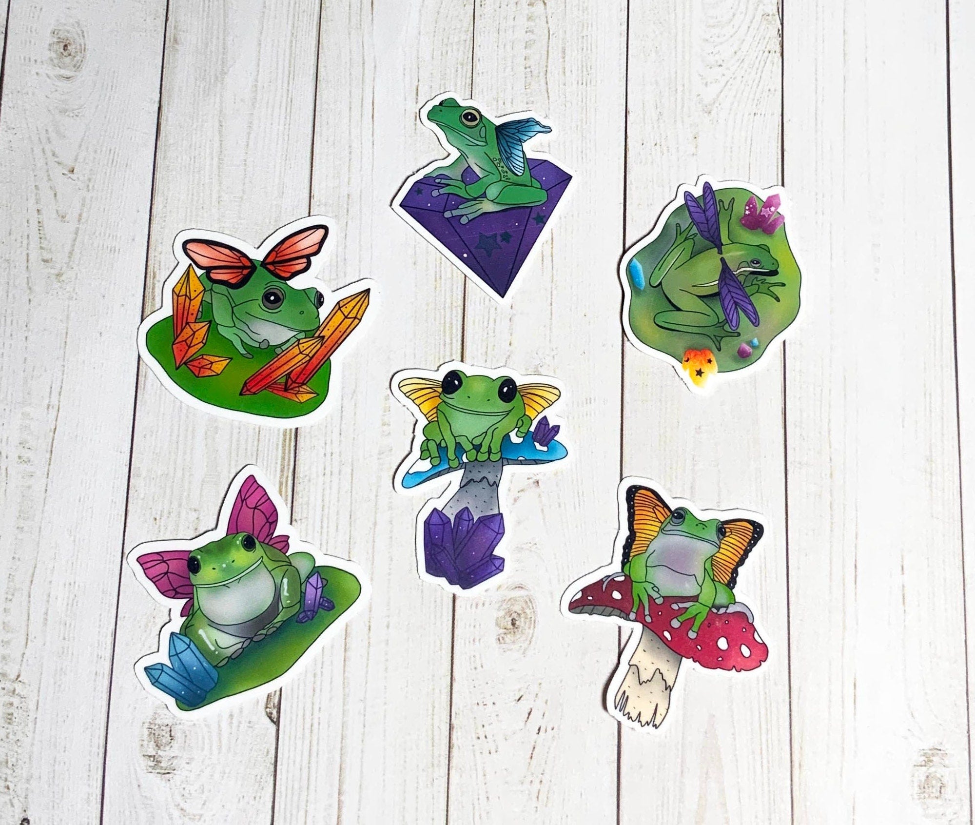 A colorful pack of six fairy frog stickers, showcasing whimsical designs on high-quality matte vinyl.