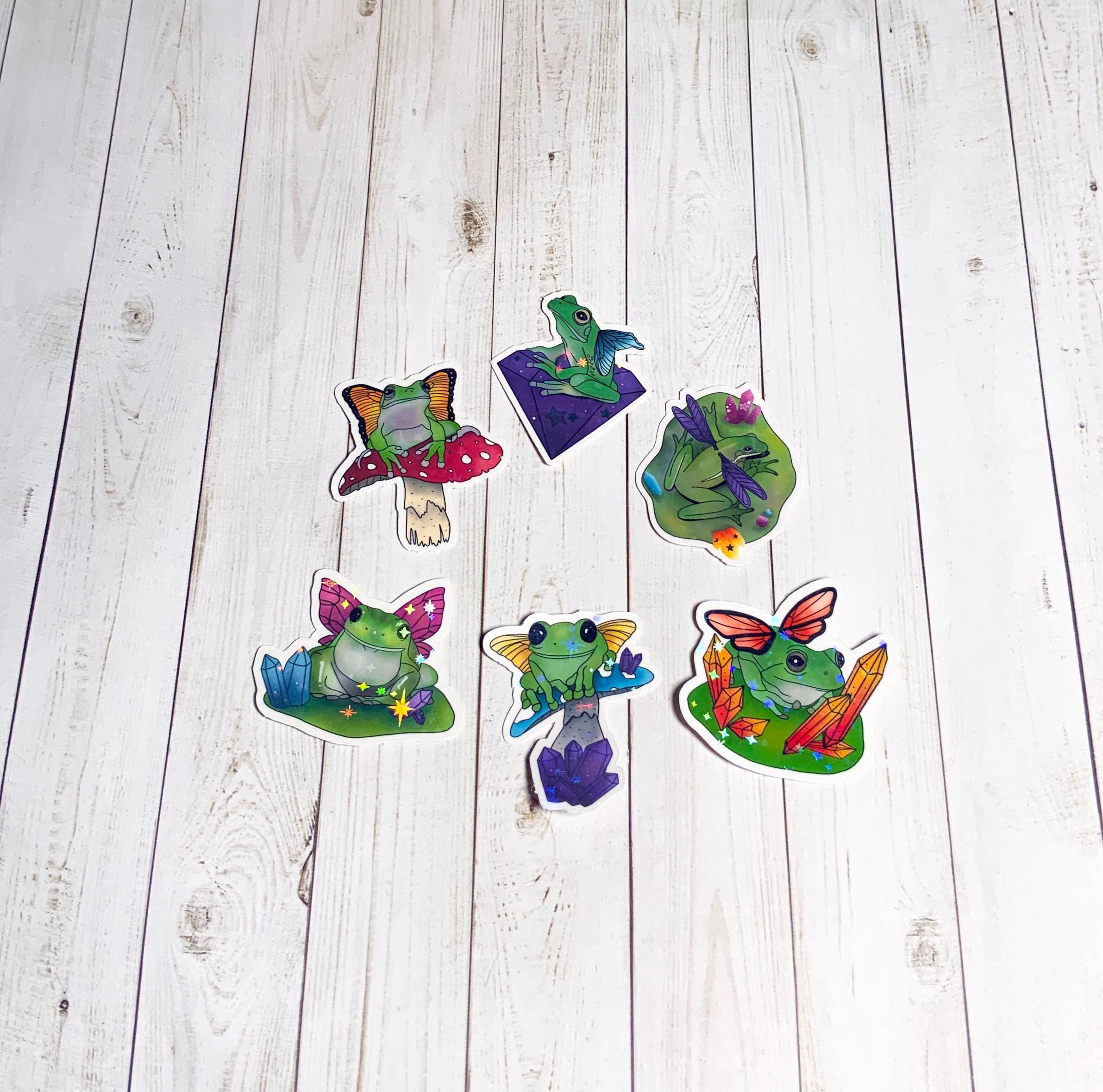 A colorful pack of six fairy frog stickers, showcasing whimsical designs on high-quality matte vinyl.