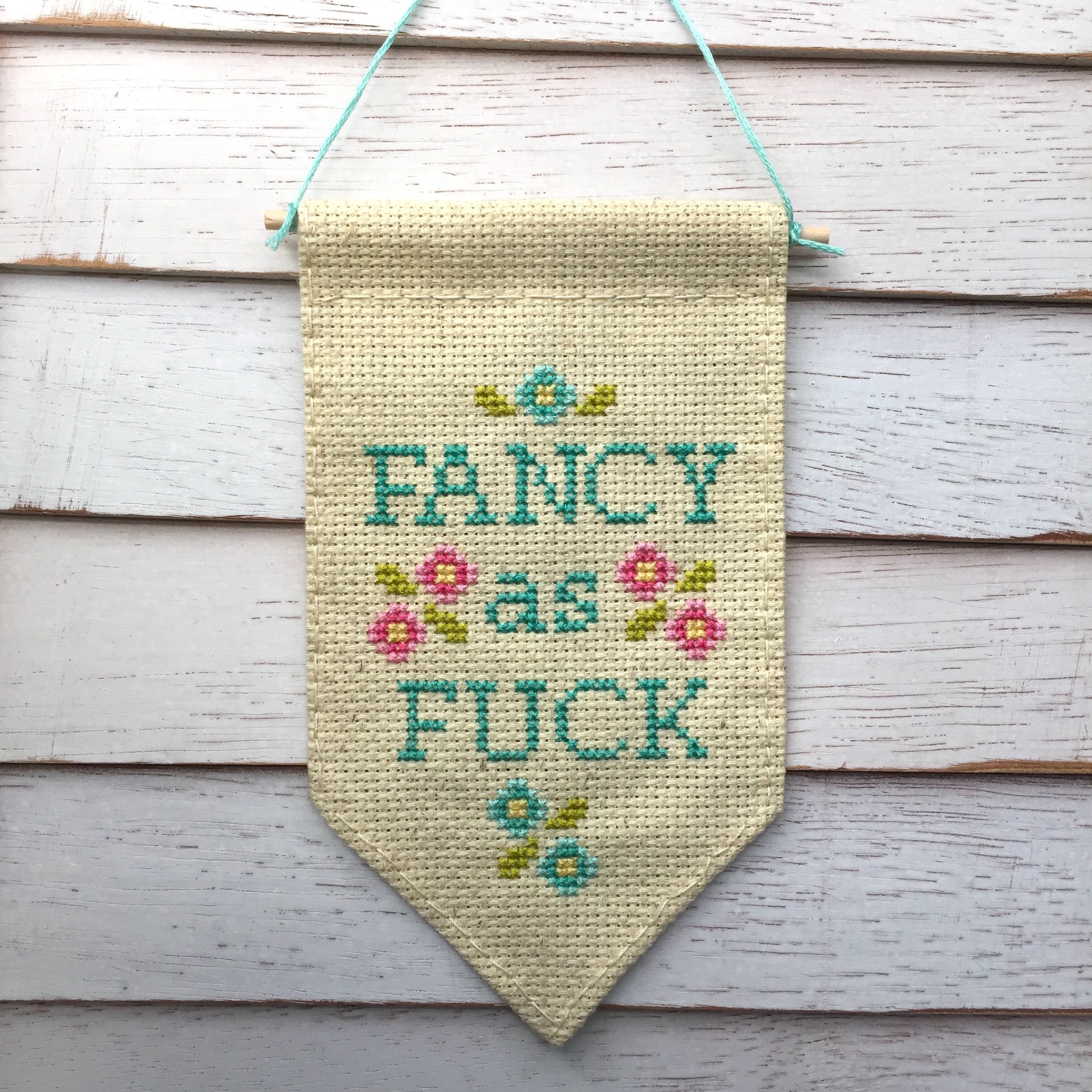 Fancy as F*ck Tiny Banner Counted Cross Stitch Kit featuring pastel threads on oatmeal fabric.