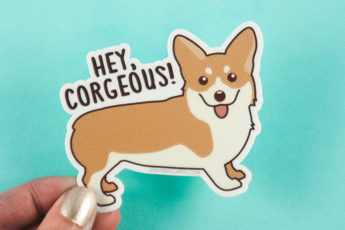 A colorful vinyl sticker featuring a happy corgi with the pun 'Hey Corgeous!' perfect for personalizing items.