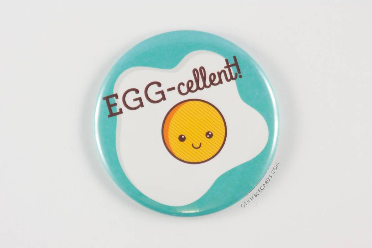 A 2.25-inch round Funny Fried Egg Magnet featuring a kawaii fried egg design with the pun 'Egg-cellent!' in vibrant colors.