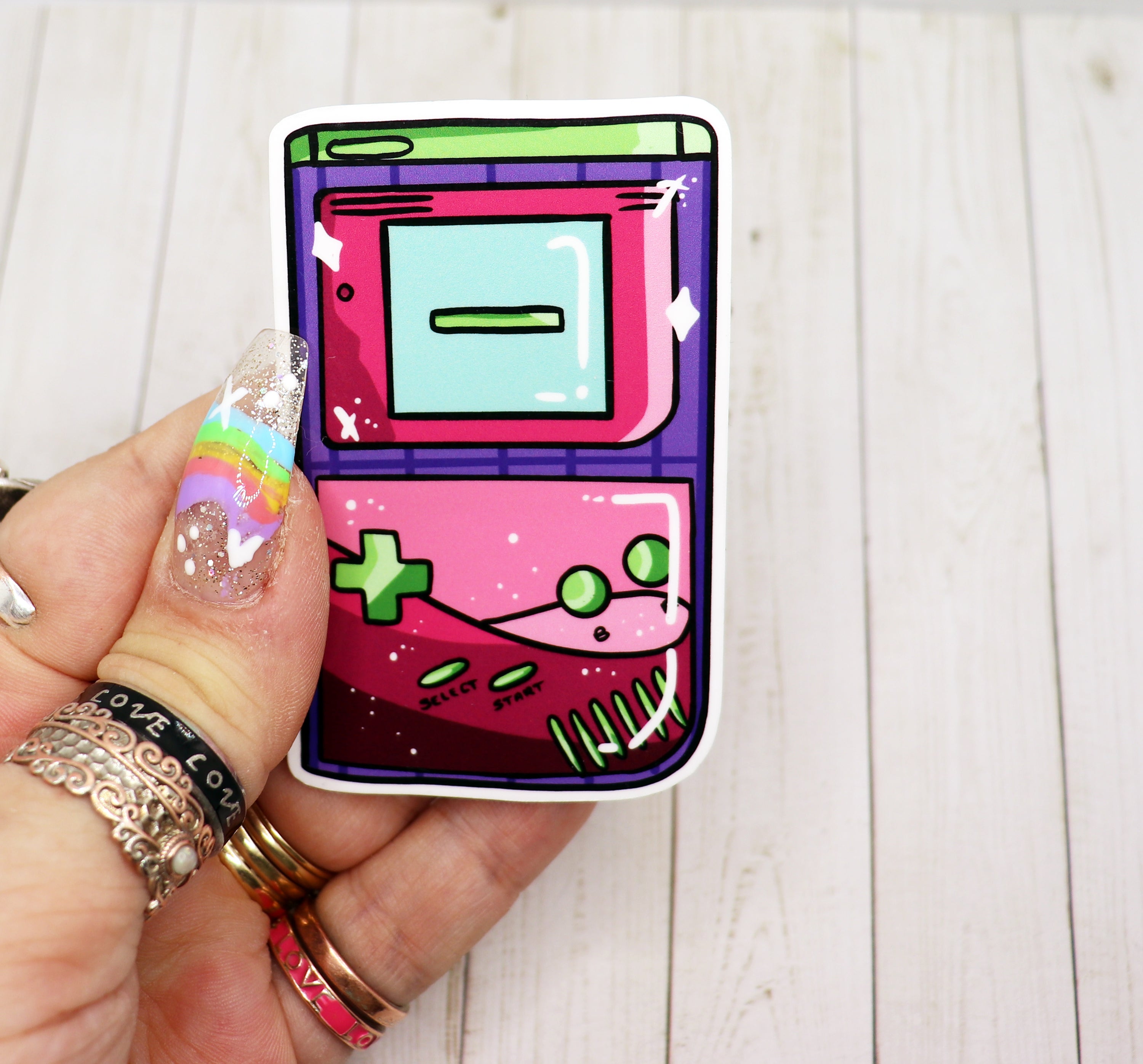 A colorful Gameboy vinyl sticker featuring retro gaming design, perfect for personalizing items.