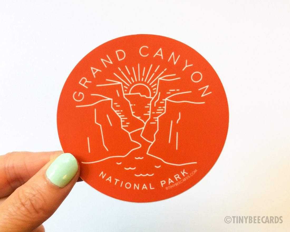 A vibrant vinyl sticker featuring the Grand Canyon illustration with a burnt orange red background, perfect for outdoor enthusiasts.