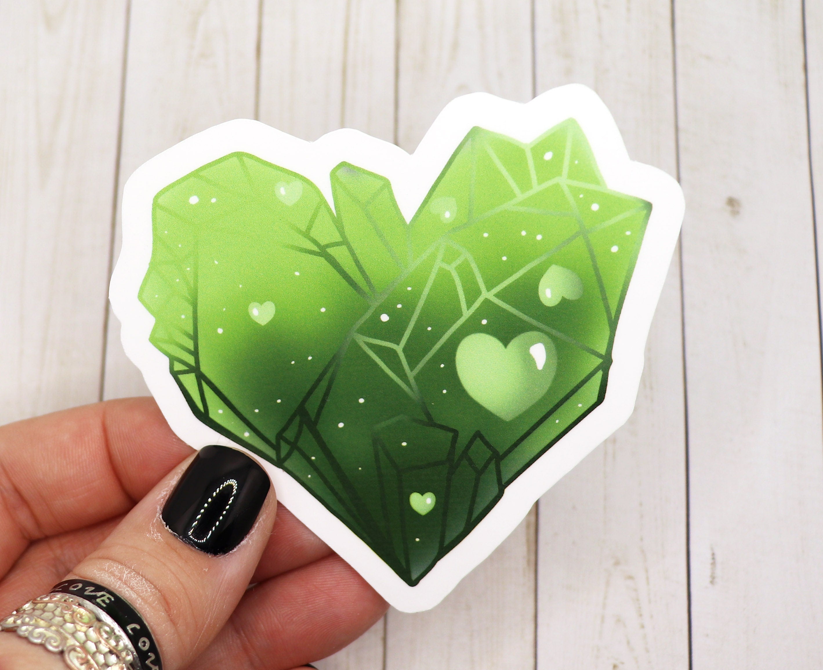 A vibrant green crystal heart sticker on a white background, showcasing its glossy finish and intricate design.