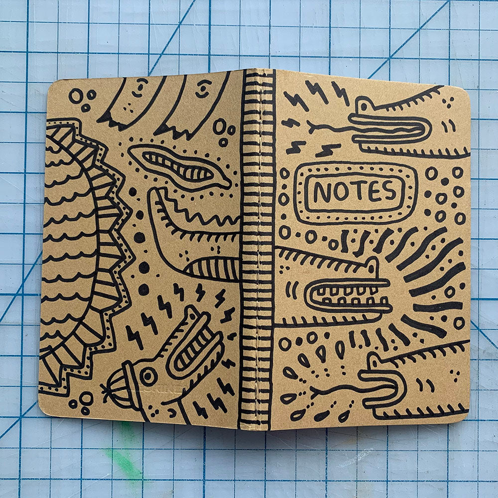 Hand-decorated Moleskine journal featuring reptile designs on front and back covers, signed by the artist.