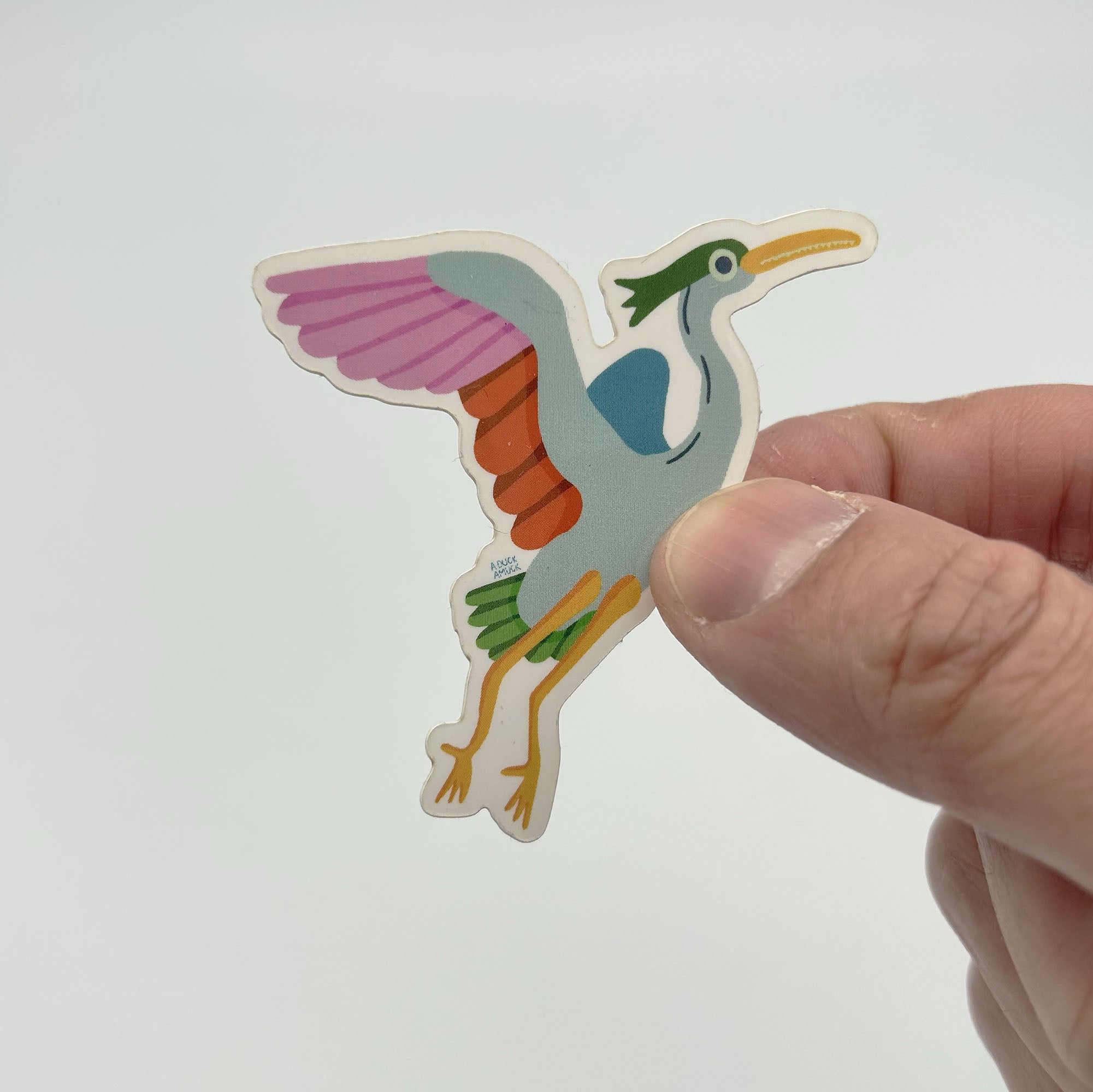 A glossy vinyl sticker featuring a beautifully designed heron, measuring 2.5 inches square, ideal for personalizing items.