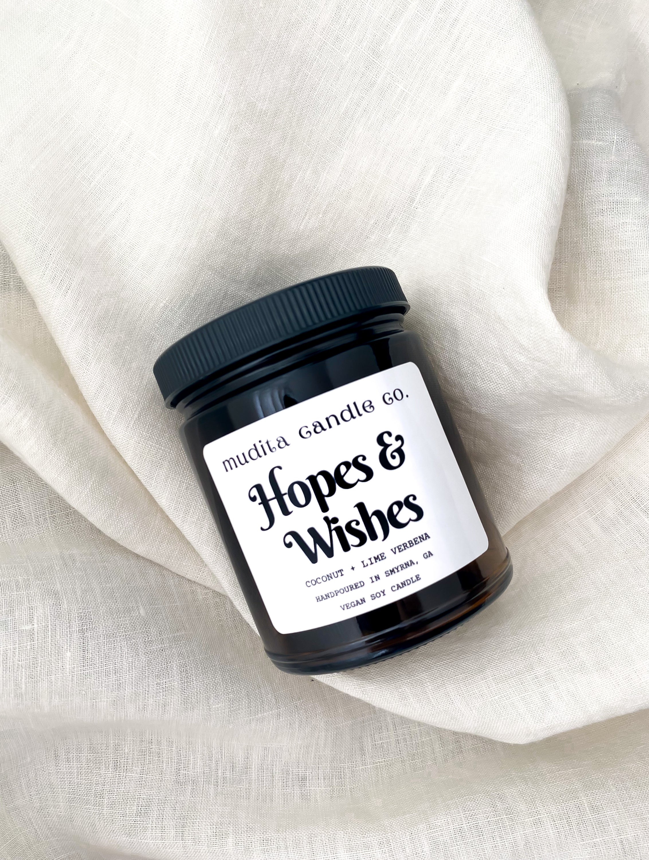 Hopes & Wishes 9oz Candle in amber glass jar with black lid, featuring tropical coconut and lime scent.