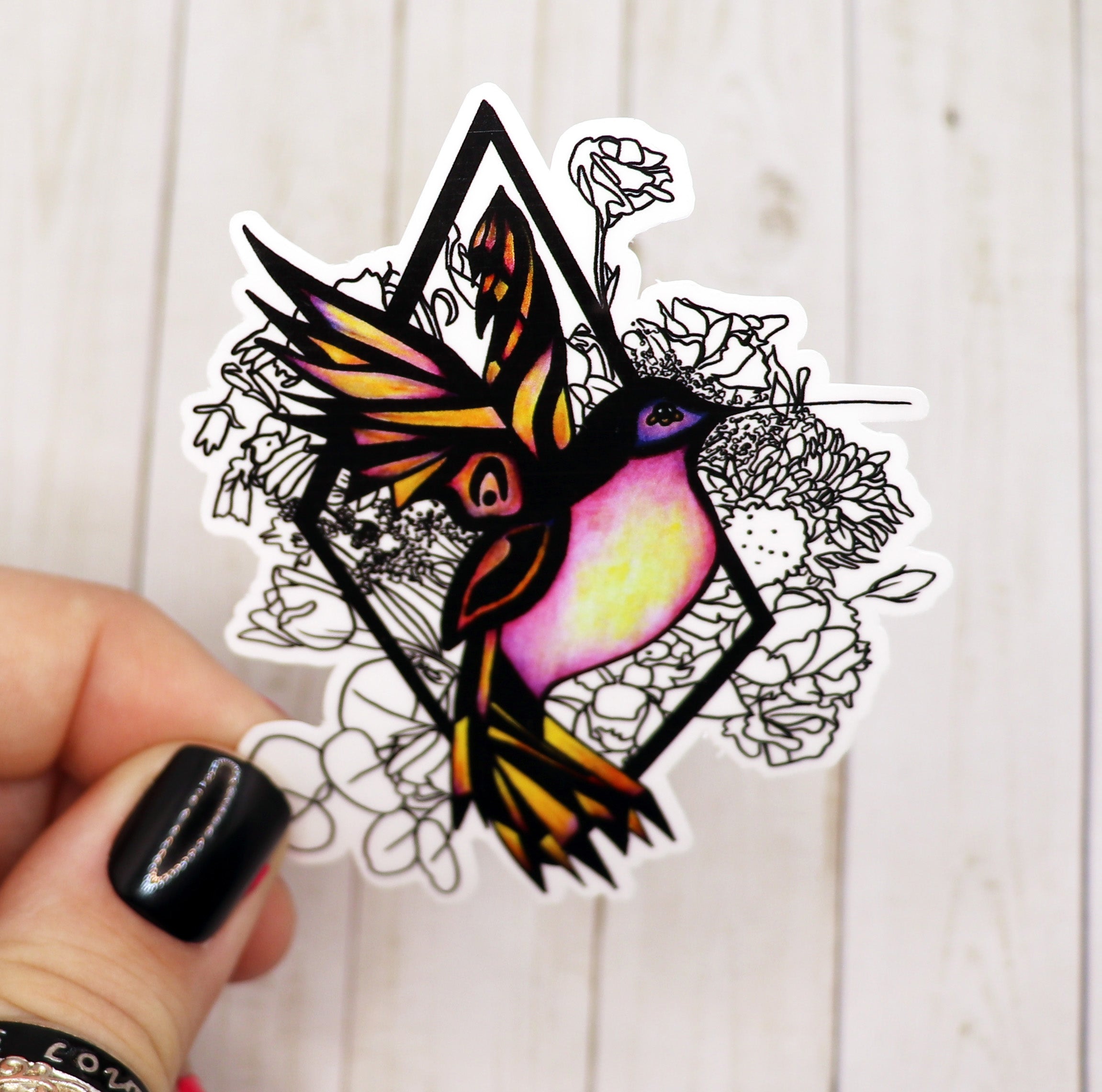 A vibrant 3-inch hummingbird sticker on a matte vinyl surface, showcasing intricate details and colors.