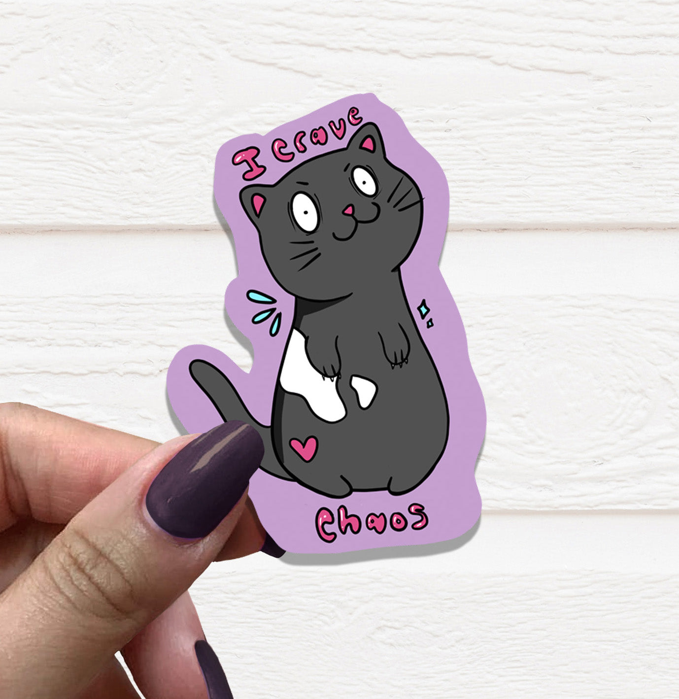 A vibrant I Crave Chaos Cat Vinyl Sticker featuring a playful cat design, perfect for personalizing various items.