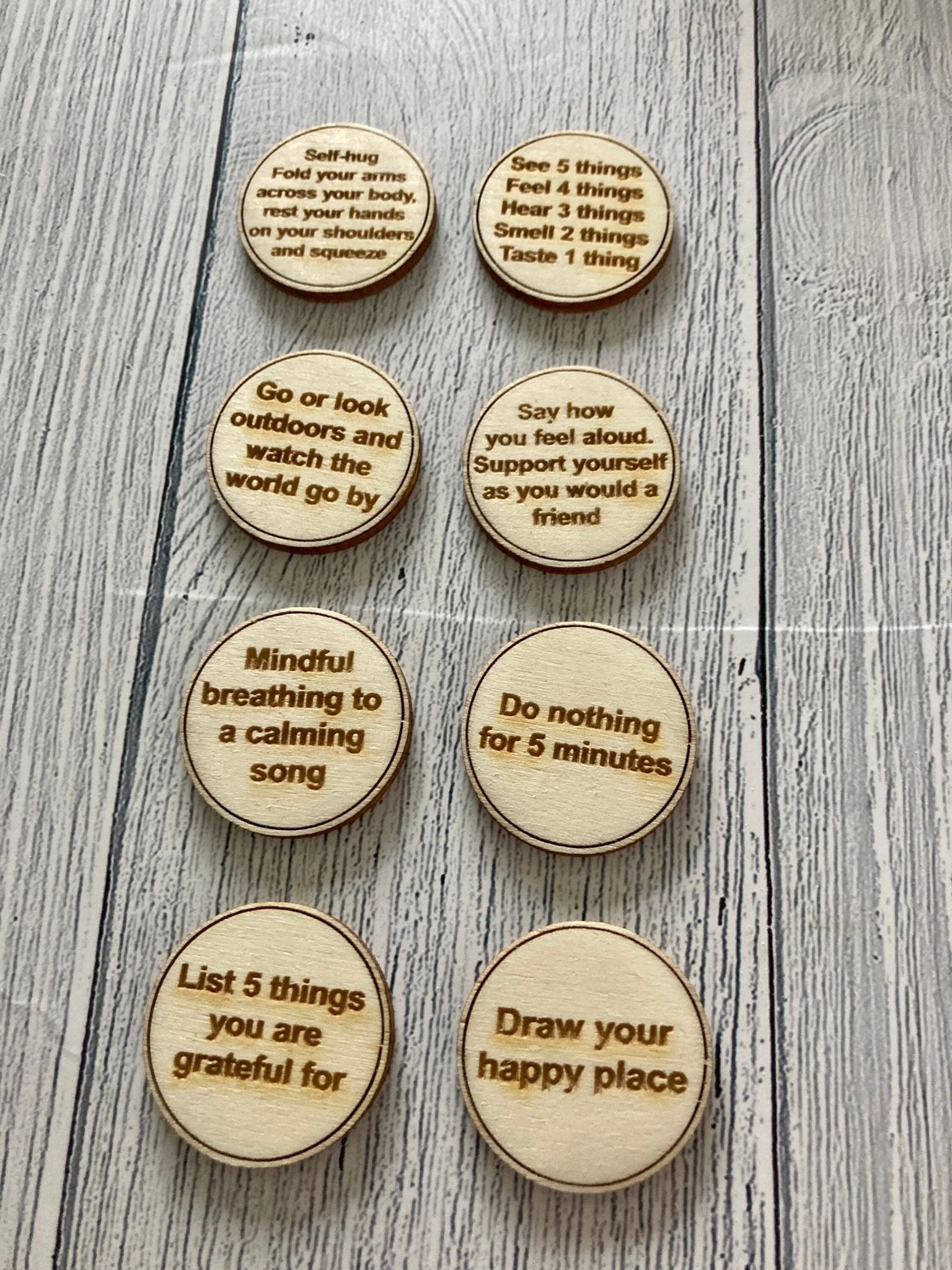 A collection of Inner Calm Coins in a jute bag, showcasing their wooden texture and mindfulness messages.