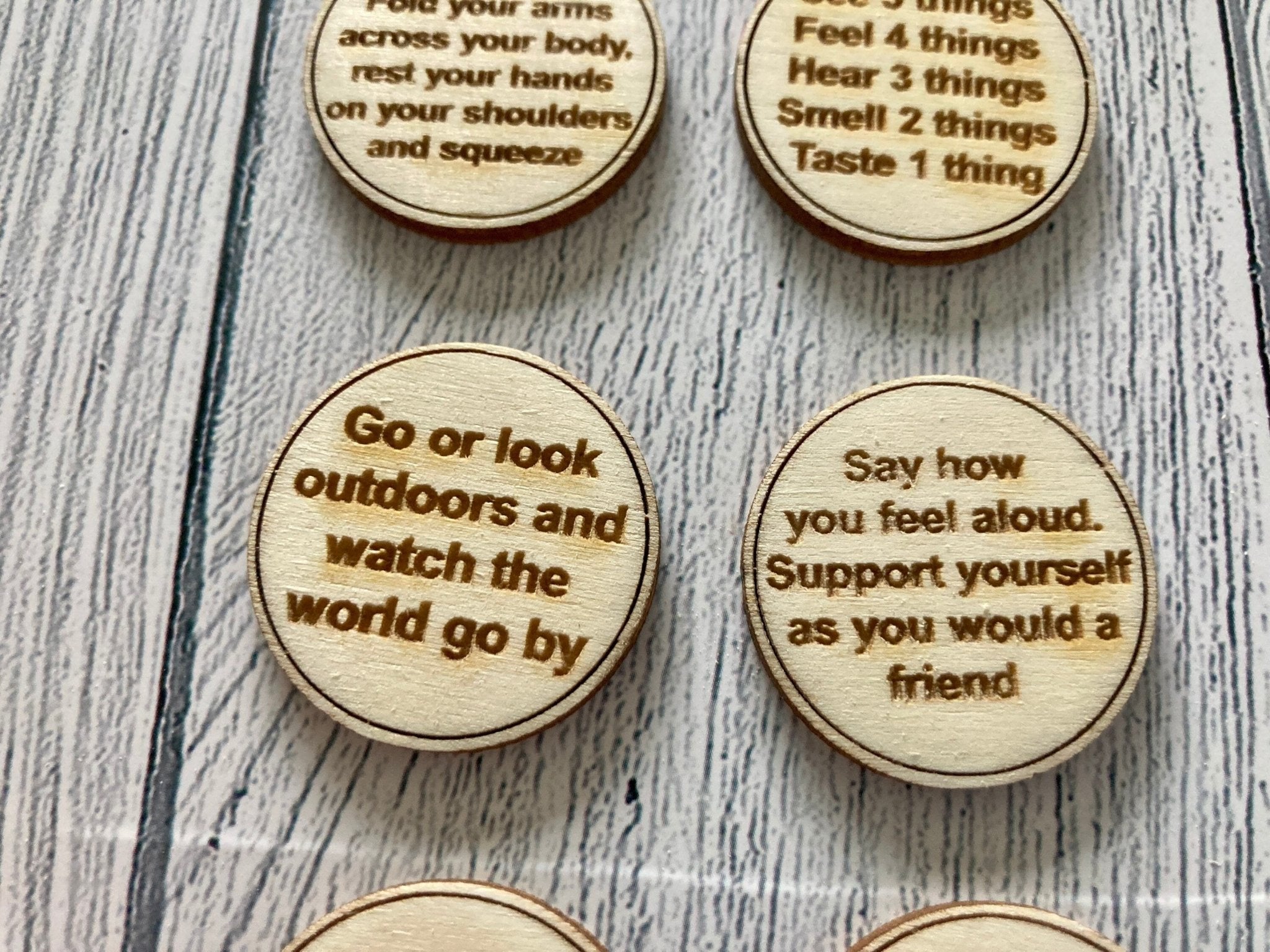 A collection of Inner Calm Coins in a jute bag, showcasing their wooden texture and mindfulness messages.