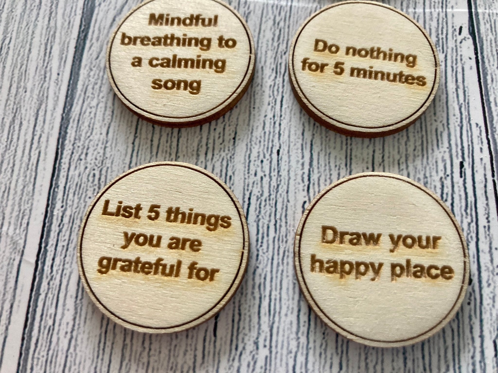 A collection of Inner Calm Coins in a jute bag, showcasing their wooden texture and mindfulness messages.