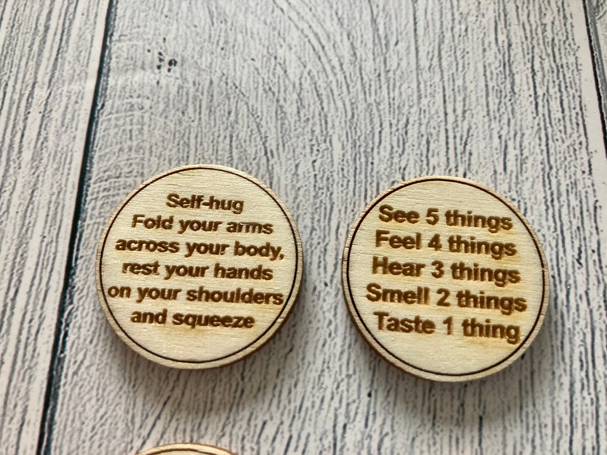 A collection of Inner Calm Coins in a jute bag, showcasing their wooden texture and mindfulness messages.