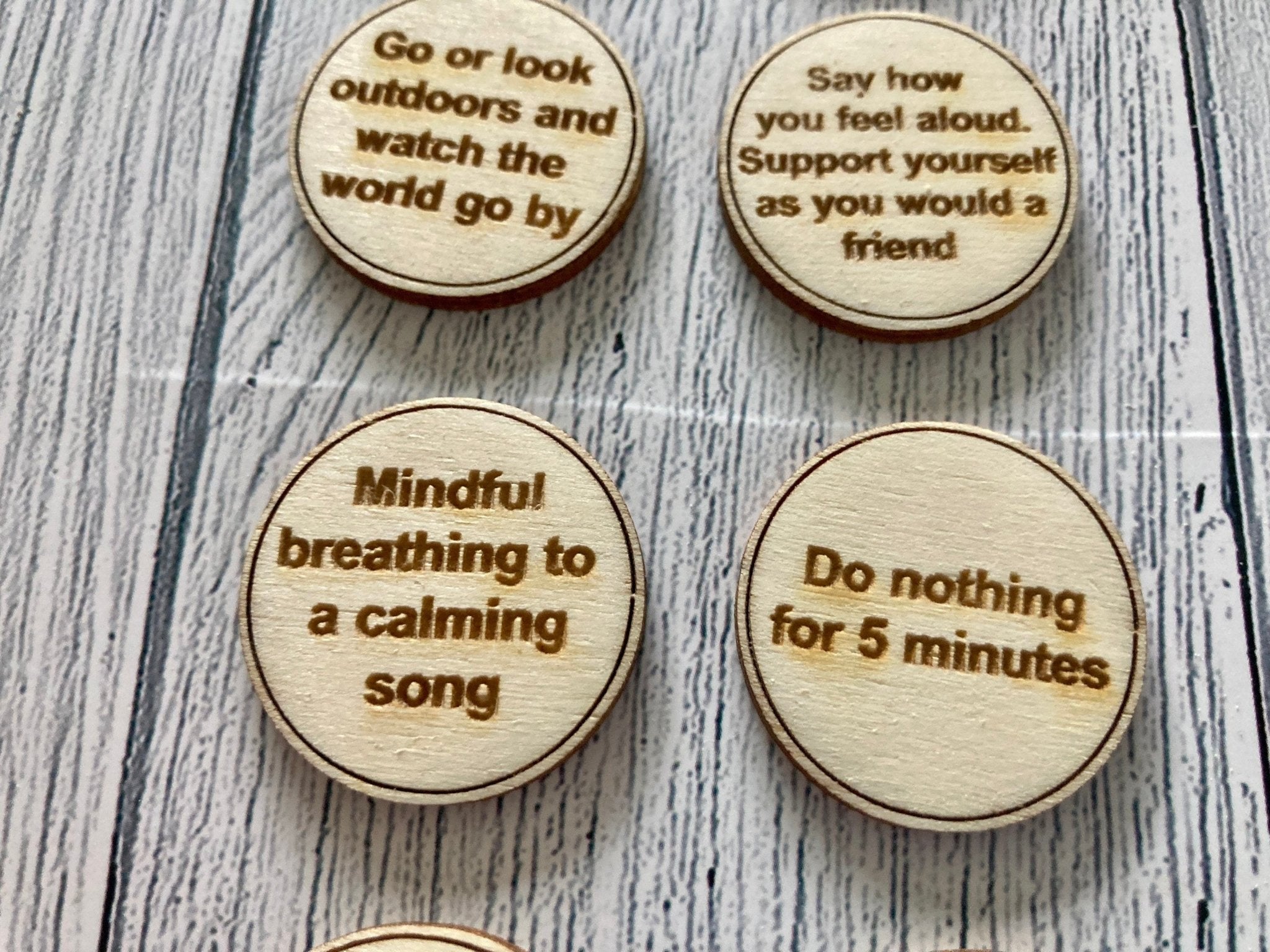 A collection of Inner Calm Coins in a jute bag, showcasing their wooden texture and mindfulness messages.