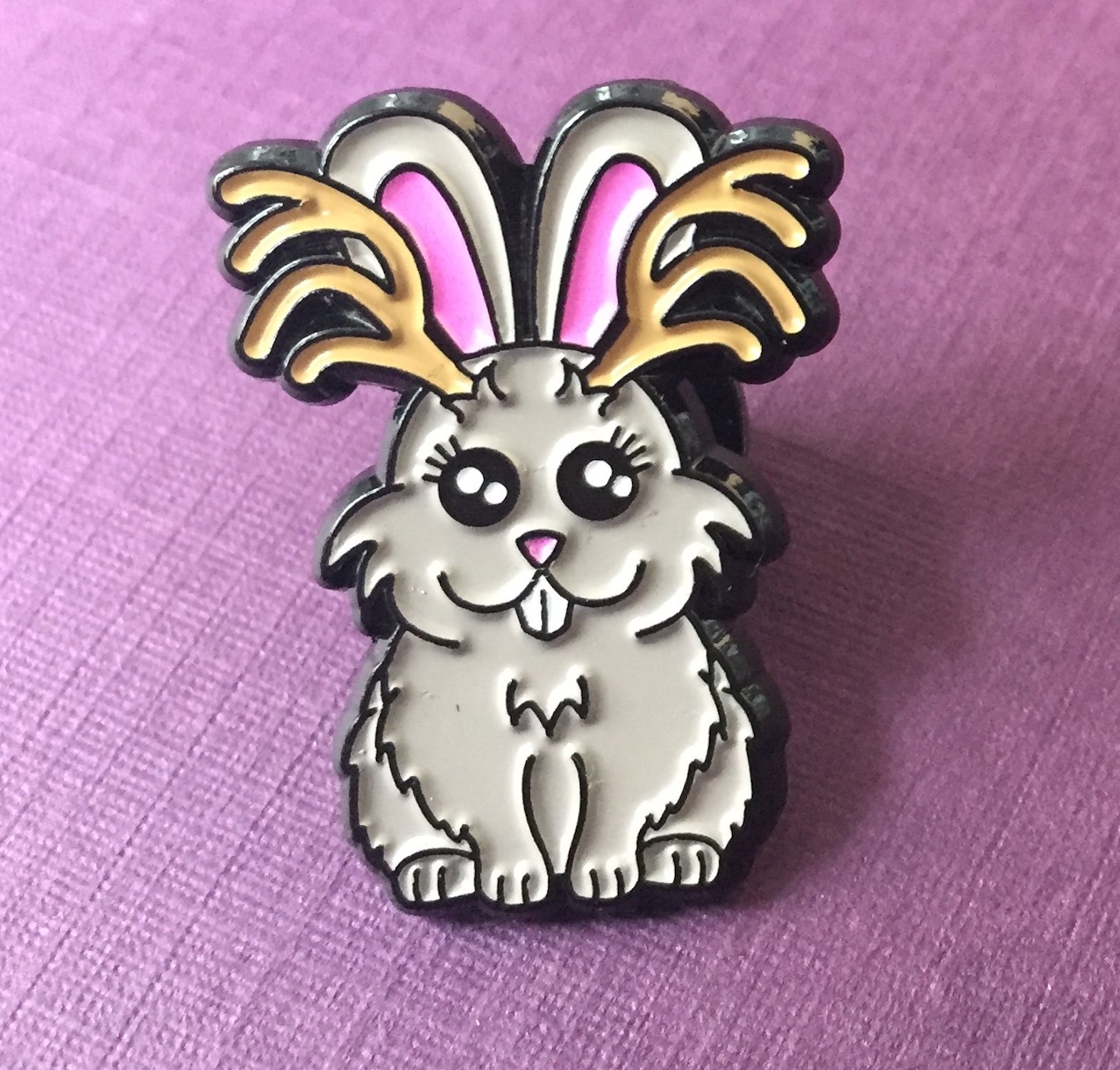 A colorful 1-inch soft enamel pin featuring a whimsical Jackalope design from the Cryptid Collection, showcasing intricate details and vibrant colors.