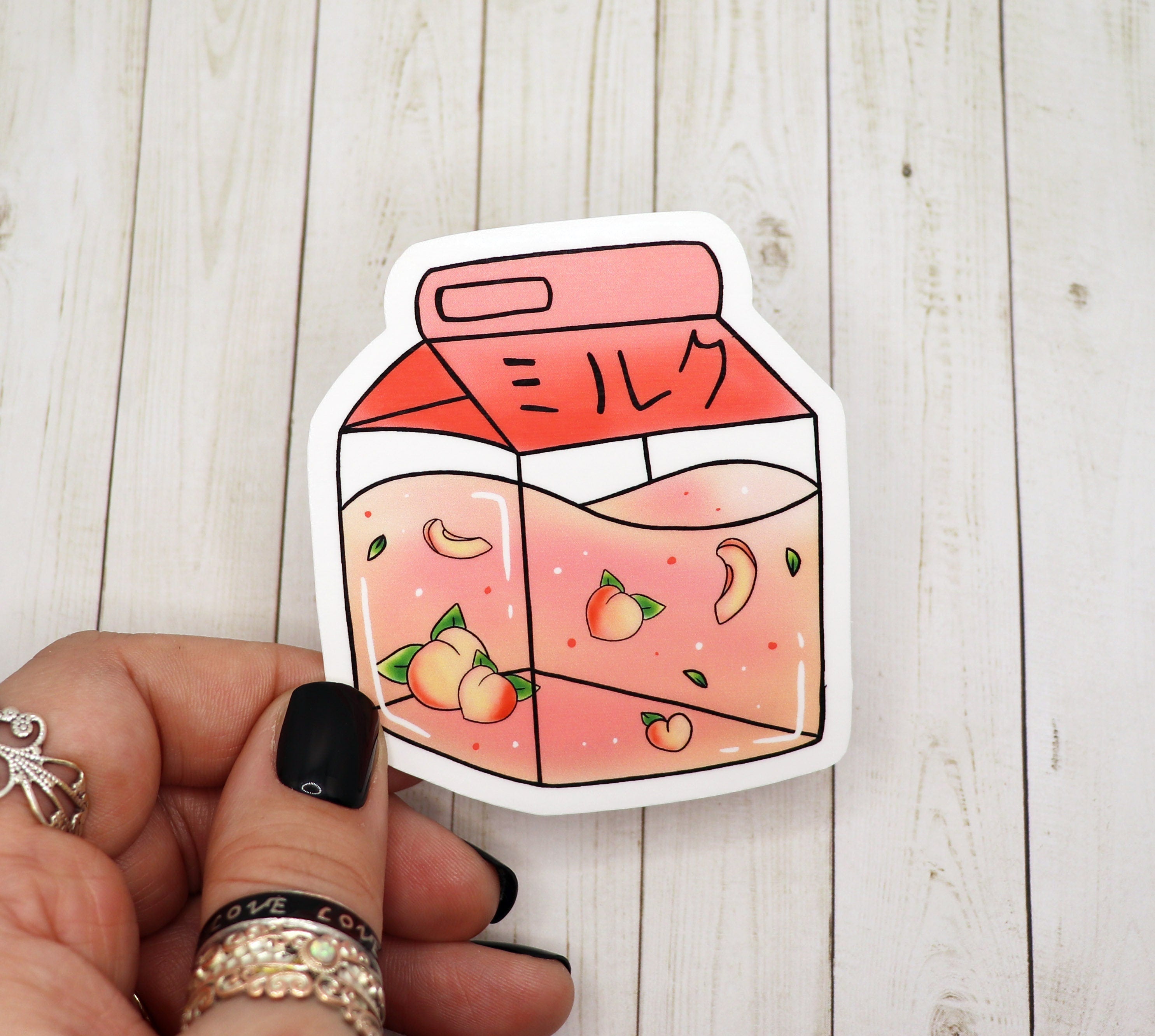 Kawaii peach milk carton sticker on a white background, showcasing its cute design and matte finish.