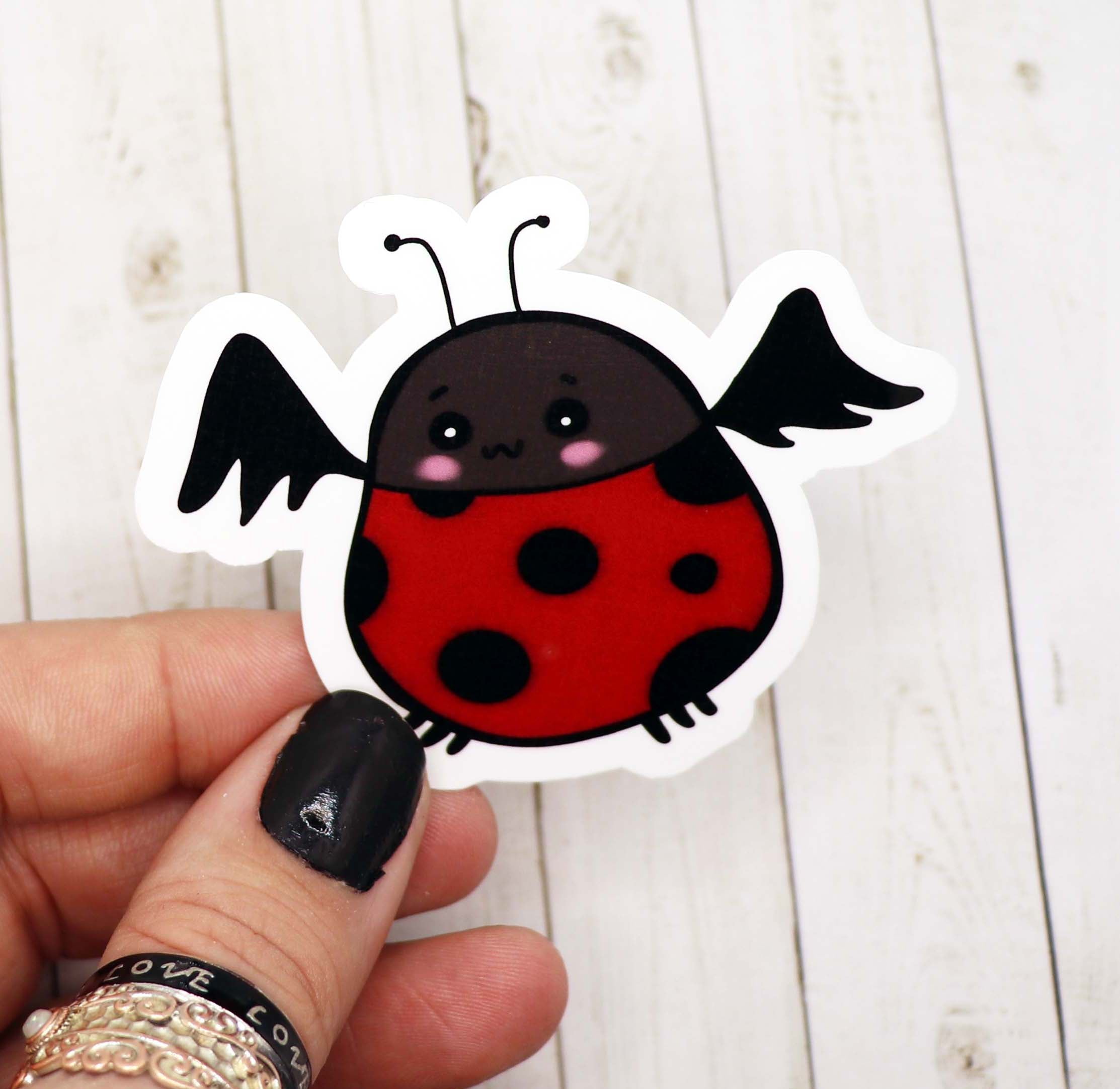 A colorful Ladybug Bat Vinyl Sticker featuring a whimsical design, perfect for personalizing various items.