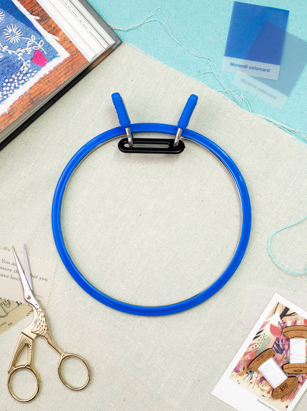 Nurge Large Spring Metal Embroidery Hoop in deep blue, showcasing its two-part design with a plastic ring and flexible metal ring.