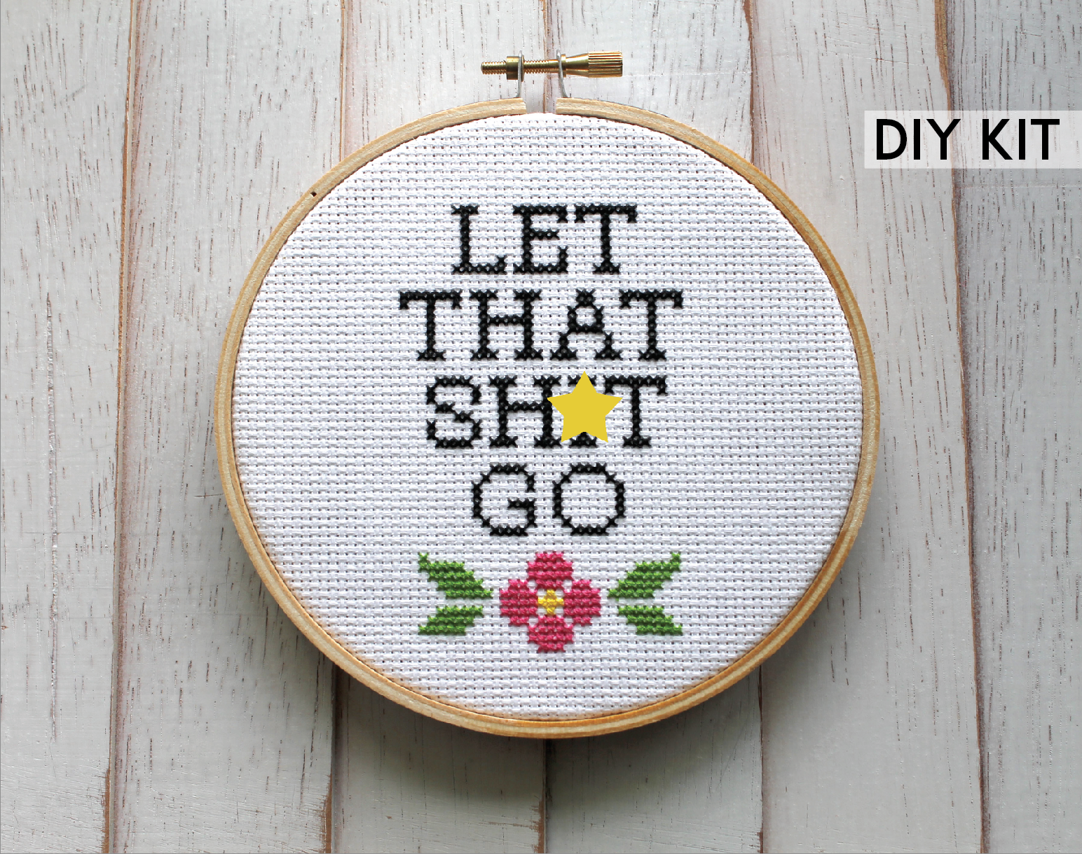 Let That Sh*t Go Counted Cross Stitch DIY Kit featuring floral elements and text, complete with all necessary supplies.