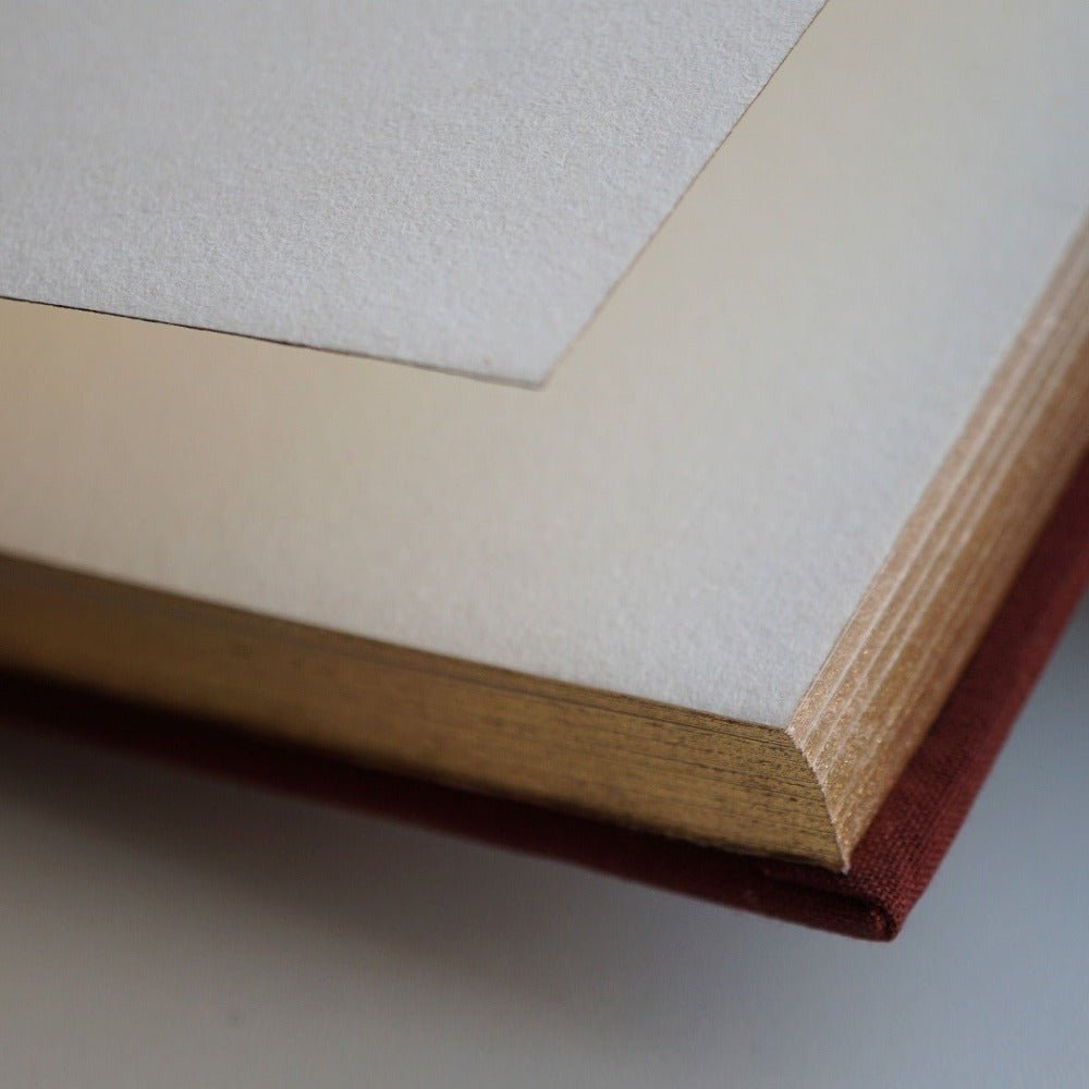 Luxury linen sketchbook with thick paper and gold edging, featuring a silk ribbon bookmark and protective hardback sleeve.