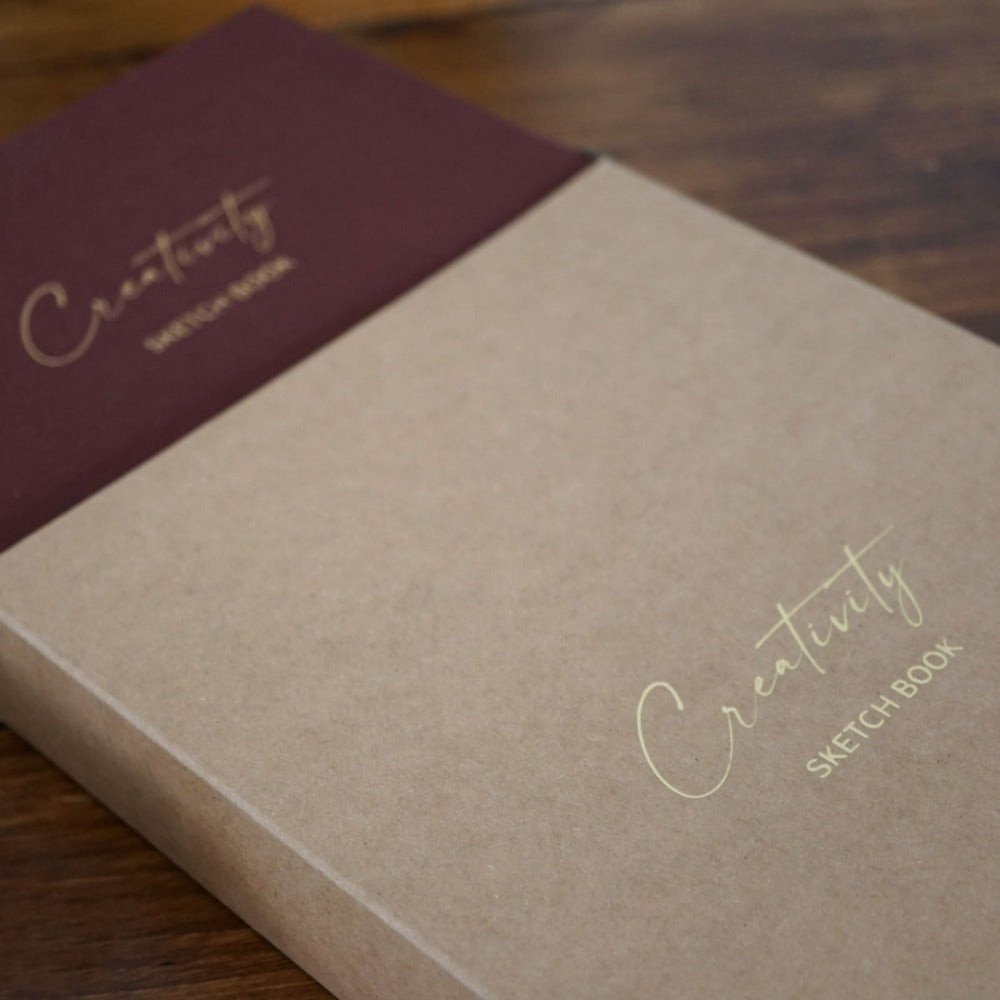 Luxury linen sketchbook with thick paper and gold edging, featuring a silk ribbon bookmark and protective hardback sleeve.